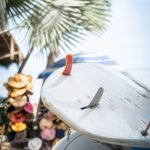 wahine project surf retreat Mexico photography of surfboards stacked and palm trees and hats blurred in the background